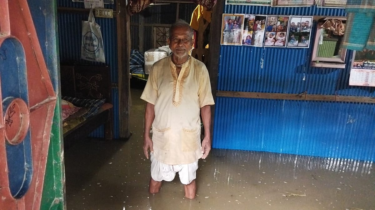 ঘরের ভেতরে হাঁটু সমান পানিতে দাঁড়িয়ে আছেন সুভাষ চক্রবর্তী। আজ সকালে চট্টগ্রামের সীতাকুণ্ড উপজেলার বাঁশবাড়িয়া ইউনিয়নের বাদামতল এলাকায়
