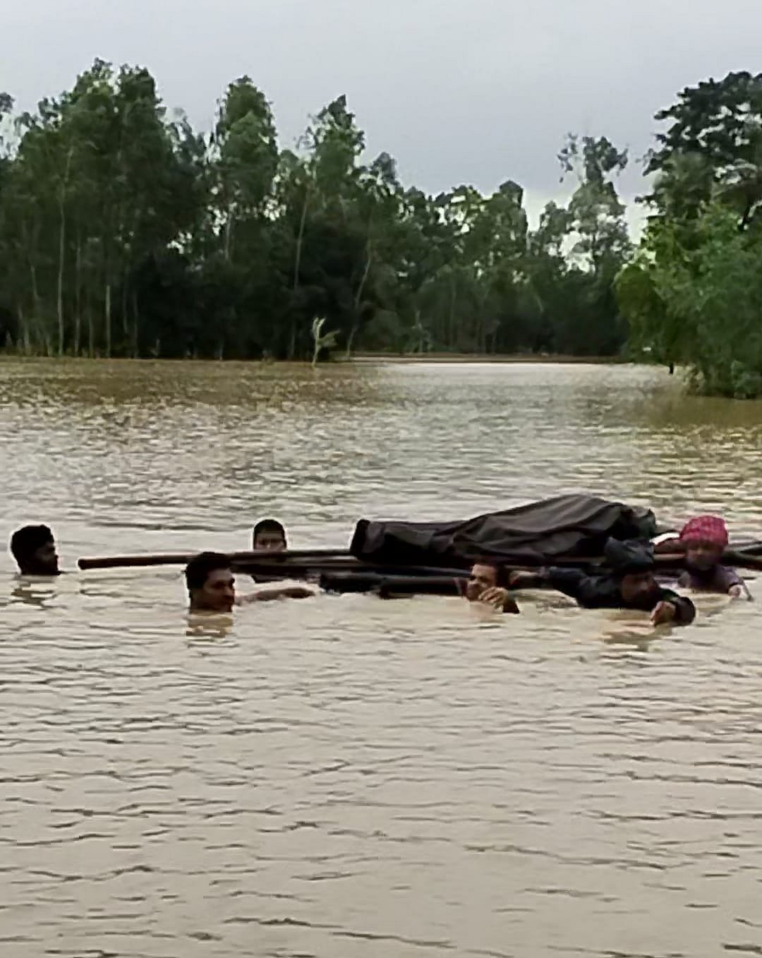 লাশ ভেলায় ভাসিয়ে নিয়ে যাচ্ছেন বাসিন্দারা। চট্টগ্রামের সাতকানিয়ার জনার কেঁওচিয়া ইউনিয়নে। গত শুক্রবার সন্ধ্যায়