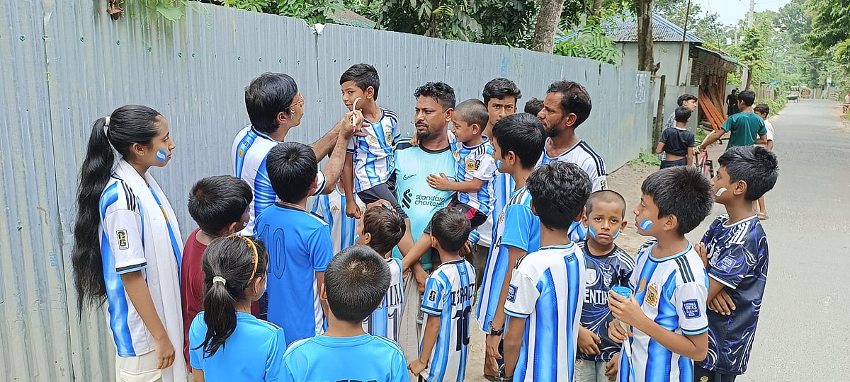 পাবনার বেড়ার বনগ্রাম মহল্লার চিত্রশিল্পী হাসমত আলী বিনা মূল্যে শিশু-কিশোরদের মুখে ও হাতে আর্জেন্টিনার পতাকা এঁকে দিচ্ছেন। বুধবার দুপুরে