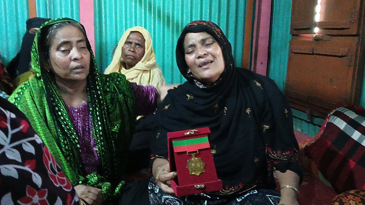 নারায়ণগঞ্জের শীতলক্ষ্যা নদীতে নিহত ডুবুরি সাদিক হোসেনের মা ছেলের পদক হাতে নিয়ে আহাজারি করছেন। আজ শুক্রবার সকালে গোয়ালন্দ পৌরসভার কুমড়াকান্দি গ্রামের বাড়িতে