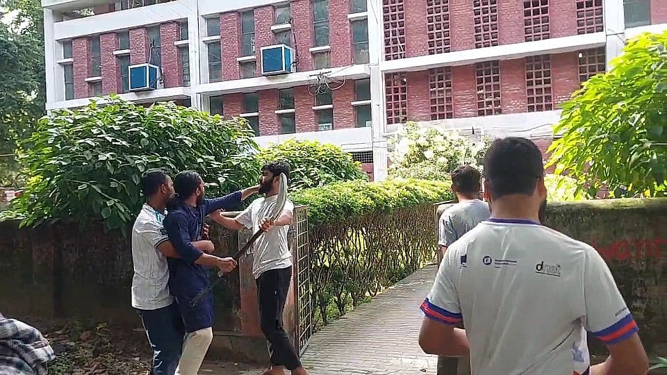 বেলচা হাতে রাজশাহী বিশ্ববিদ্যালয়ের কেন্দ্রীয় গ্রন্থাগারের দিকে তেড়ে যাচ্ছেন রাকসু জিএস সালাউদ্দিন আম্মার। সোমবার বিকেলে