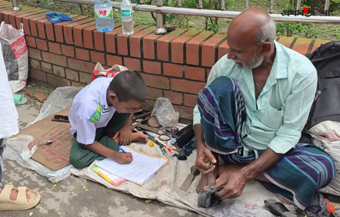 নিজের কাজে ব্যস্ত বাবা। পাশে পড়াশোনায় মনোযোগী ছেলে। গত বৃহস্পতিবার দুপুরে মানিকগঞ্জ আদালত চত্বরে