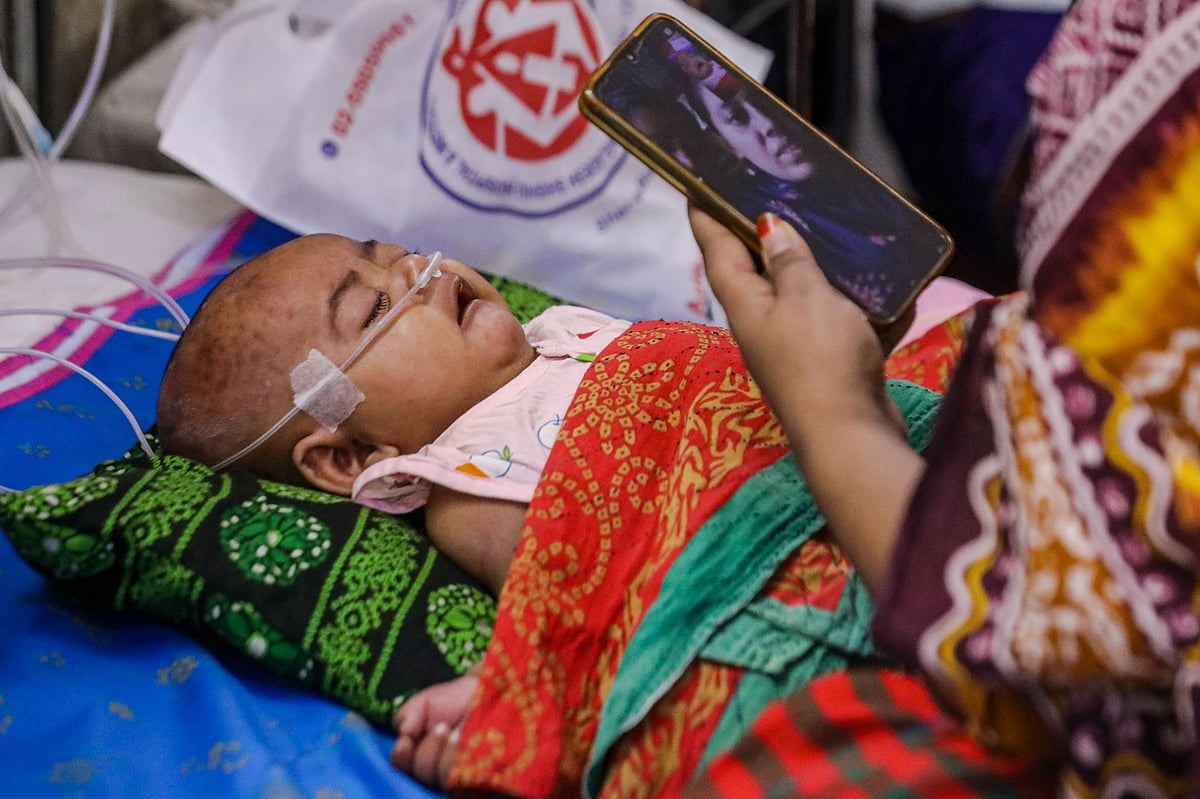 হামে আক্রান্ত হয়ে রাজধানীর আগারগাঁওয়ের শিশু হাসপাতালে চিকিৎসাধীন এক শিশু। শয্যাপাশে বসে ভিডিও কলে শিশুটিকে স্বজনদের দেখাচ্ছেন মা। ৩১ আগস্ট ২০২৬