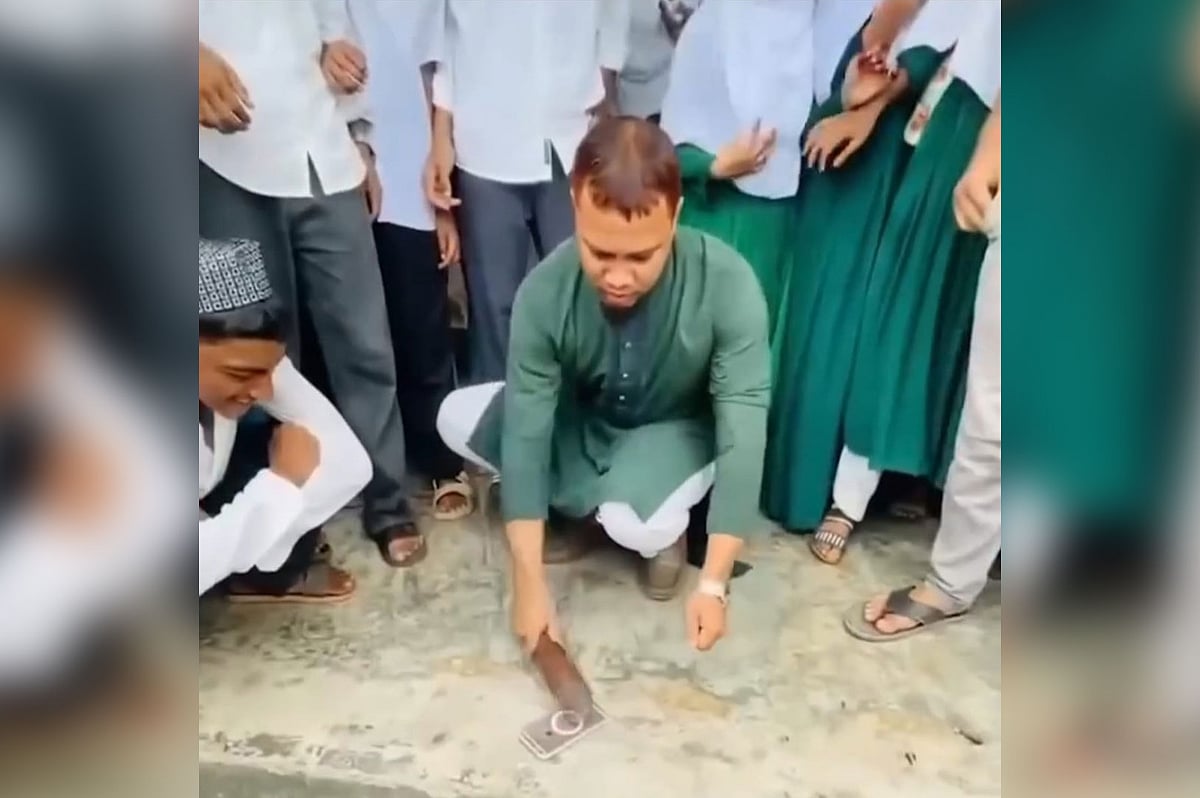 হাতুড়ি দিয়ে মুঠোফোন ভাঙছেন শিক্ষক। গোল হয়ে দাঁড়িয়ে দেখছে শিক্ষার্থীরা