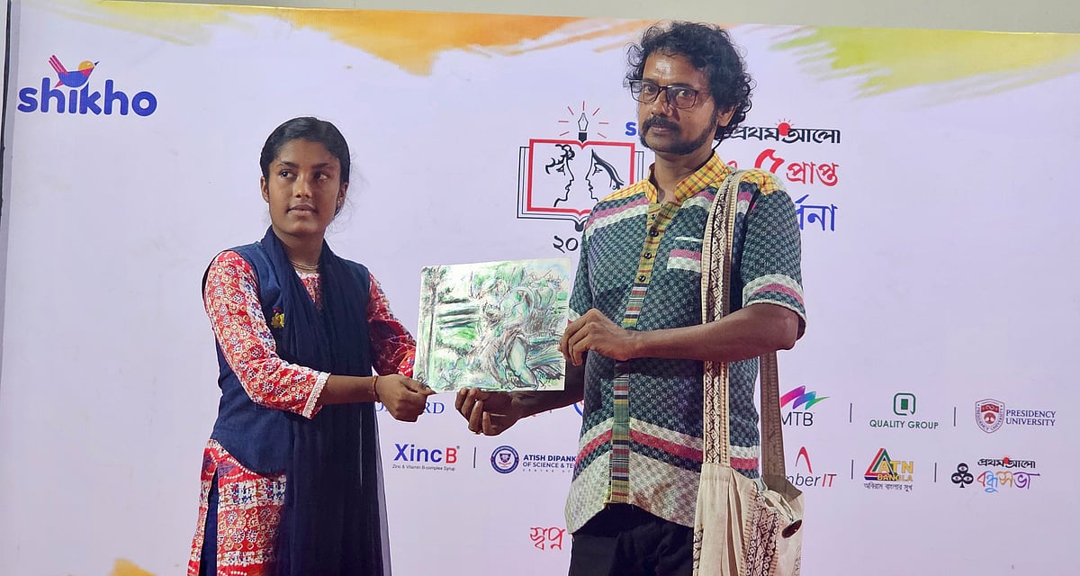 নড়াইলে সংবর্ধনা অনুষ্ঠানে কৃতী শিক্ষার্থী পূজা বিশ্বাসকে নিজের আঁকা ছবি উপহার দিচ্ছেন শিল্পী ধর্মদাস মল্লিক। বুধবার সকালে জেলা শিল্পকলা একাডেমি মিলনায়তনে