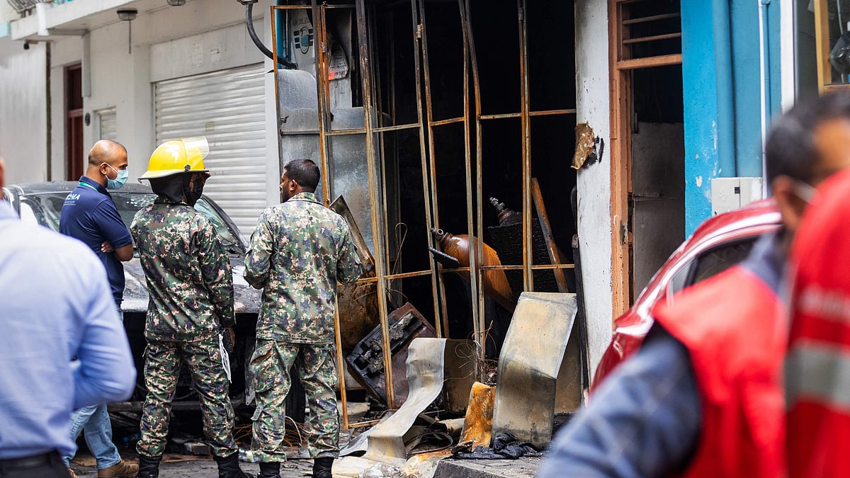 Firefighters and emergency personnel stand outside a building after a major fire swept through cramped living quarters of foreign workers in the Maldives capital Male on November 10, 2022