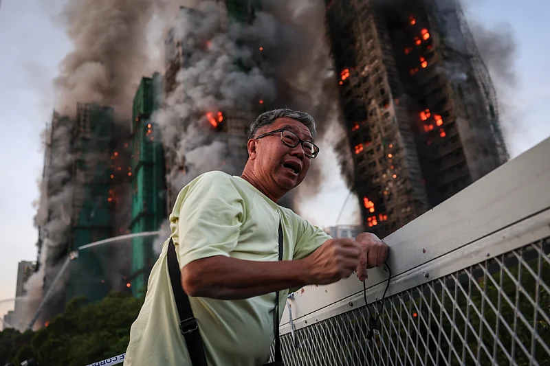 Wong, 71, reacts after saying his wife is trapped inside Wang Fuk Court during a major fire, in Tai Po, Hong Kong, China, 26 November 2025. 