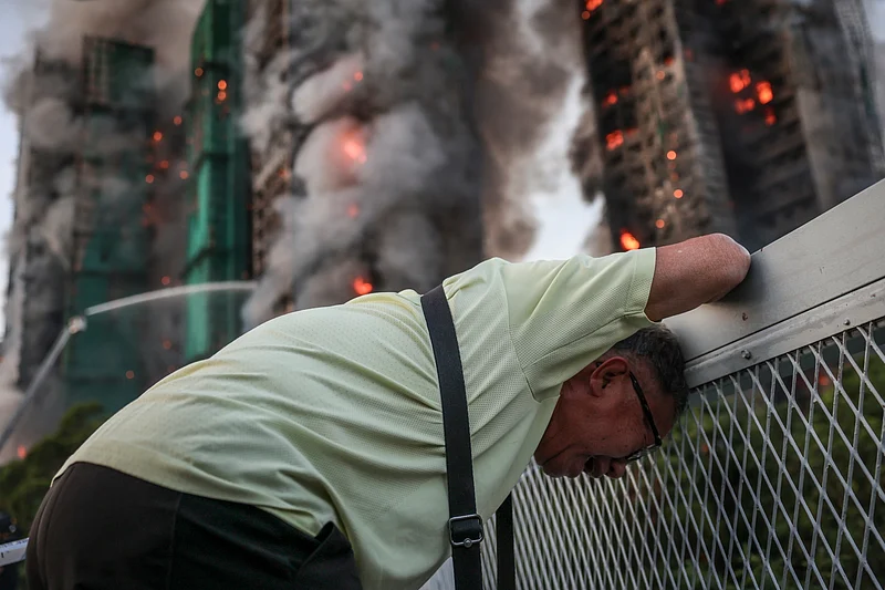 Wong, 71, reacts after saying his wife is trapped inside Wang Fuk Court during a major fire, in Tai Po, Hong Kong, China, 26 November 2025. 
