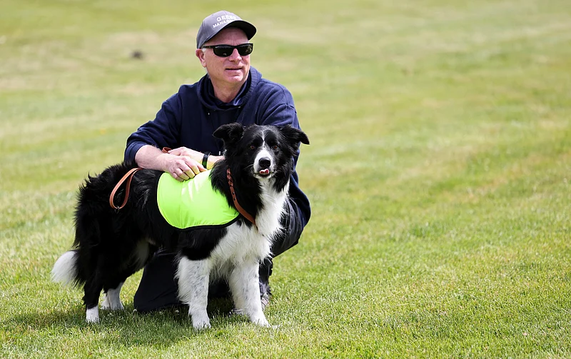 Gareth Williams, owner and operator of Border Control Bird Dogs, a specialized geese management company, holds Ben, one of two border collies hired to keep Canada geese off a FIFA World Cup training pitch, as they attend a practice session at the Centennial Park in Toronto, Canada June 24, 2026. 