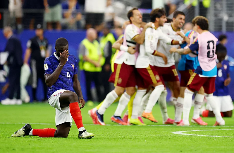 Football - FIFA World Cup 2026 - Semi Final - France v Spain - Dallas Stadium, Arlington, Texas, U.S. - July 14, 2026
France's Dayot Upamecano look dejected after the match as France are eliminated as Spain players celebrate after qualifying for the World Cup final 