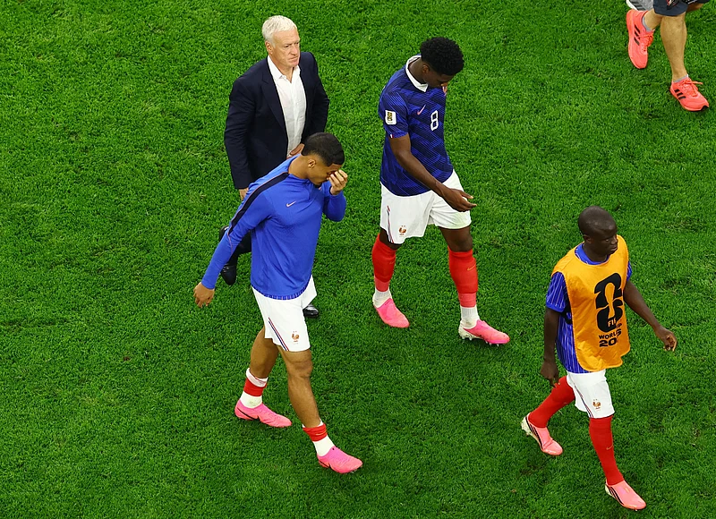 Football - FIFA World Cup 2026 - Semi Final - France v Spain - Dallas Stadium, Arlington, Texas, U.S. - July 14, 2026
France's William Saliba, Aurelien Tchouameni, and coach Didier Deschamps look dejected after the match  