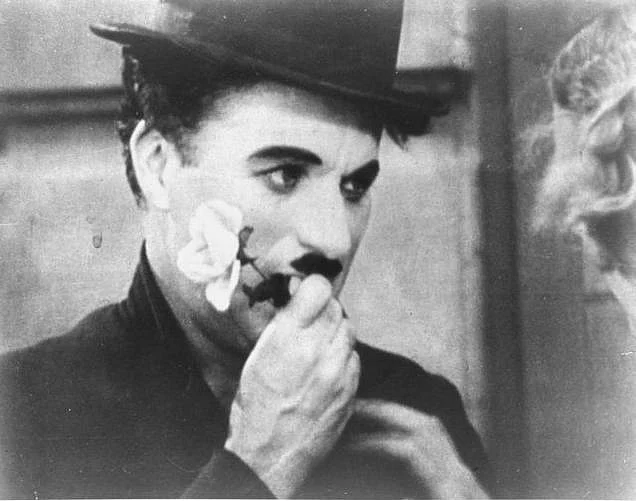 Charlie Chaplin holds a rose in this photo from the final scene in his 1931 silent film 'City Lights'. The film is among the American Film Institute's best romantic comedy movies.