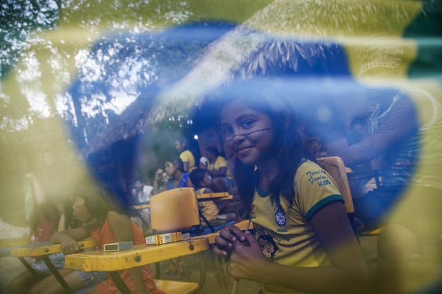 Brazilian Satere-Mawe indigenous people gather to watch the FIFA World Cup inaugural match btween Brazil and Croatia, on June 12, 2014 in Manaus, Amazonas state, Brazil. Photo: AFP