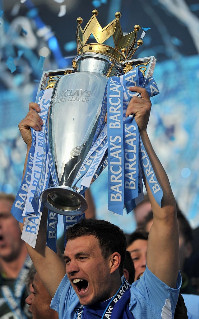 Manchester City's Bosnian striker Edin Dzeko lifts the Premier League trophy after their 3-2 victory over Queens Park Rangers in the English Premier League football match against Queens Park Rangers at The Etihad stadium in Manchester, north-west England on May 13, 2012. AFP