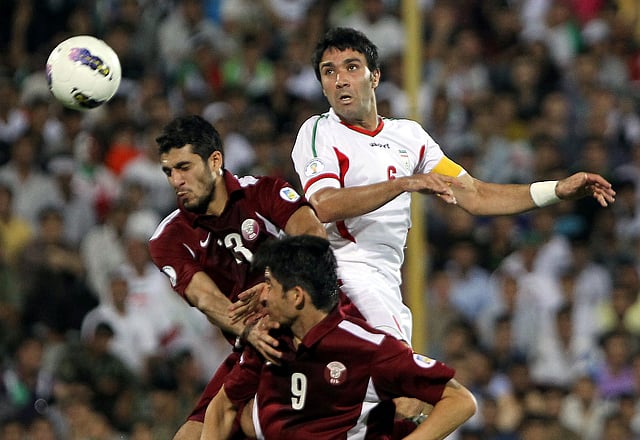 Iran's Javad Nekonam (R) vies for the ball against Qatar's Ibrahim Majed (L) during their 2014 World Cup Asian qualifying football match, at the Azadi Stadium in Tehran on June 12, 2012. The match drew 0-0. AFP