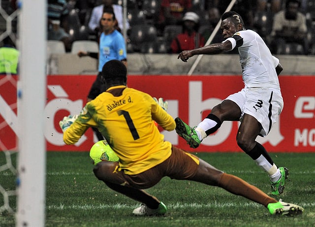 Ghana's forward Asamoah Gyan (R) strikes in front of Burkina Faso's goalkeeper Daouda Diakite during the 2013 African Cup of Nations semi-final football match Burkina Faso vs Ghana, on February 6, 2013 at Mbombela stadium in Nelspruit. AFP