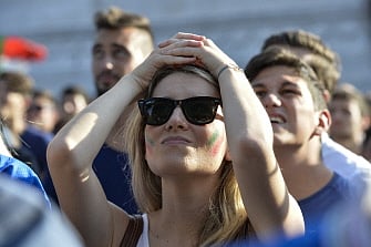 An Italian supporter reacts as she watches on a giant screen the World Cup football match Italy vs Costa Rica on June 20, 2014 on the Piazza Venezia square in Rome. AFP