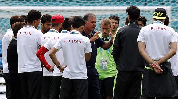 Iran's coach Carlos Queiroz (C, facing camera) gestures as he speaks to his players during a visit at the Arena Fonte Nova stadium ahead of their 2014 World Cup against Bosnia and Herzegovina in Salvador, June 24, 2014. Photo: Reuters