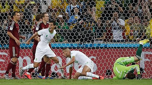 Algeria's forward Islam Slimani (2nd R) scores his team's first goal past Russia's goalkeeper Igor Akinfeev (R, in green) during a Group H football match between Algeria and Russia at the Baixada Arena in Curitiba during the 2014 FIFA World Cup on June 26, 2014. AFP