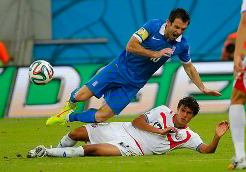 Costa Rica's Yeltsin Tejeda (bottom) fouls Greece's Giorgos Karagounis during their 2014 World Cup round of 16 game at the Pernambuco arena in Recife June 29, 2014. Photo: Reuters