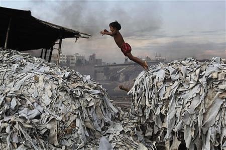 A child jumps on the waste products that are used to make poultry feed as she plays in a tannery at Hazaribagh in Dhaka October 9, 2012. Reuters