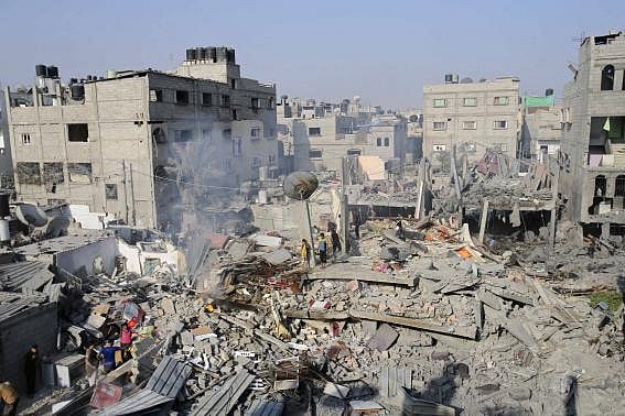 Palestinians stand atop the wreckage of a house, which witnesses said was destroyed by an Israeli air strike in Rafah, in the southern Gaza Strip, August 2, 2014. Photo: Reuters