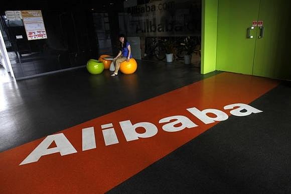 An employee sits next to a logo of Alibaba during a media tour organised by government officials at the company's headquarters on the outskirts of Hangzhou, Zhejiang province. Photo: Reuters