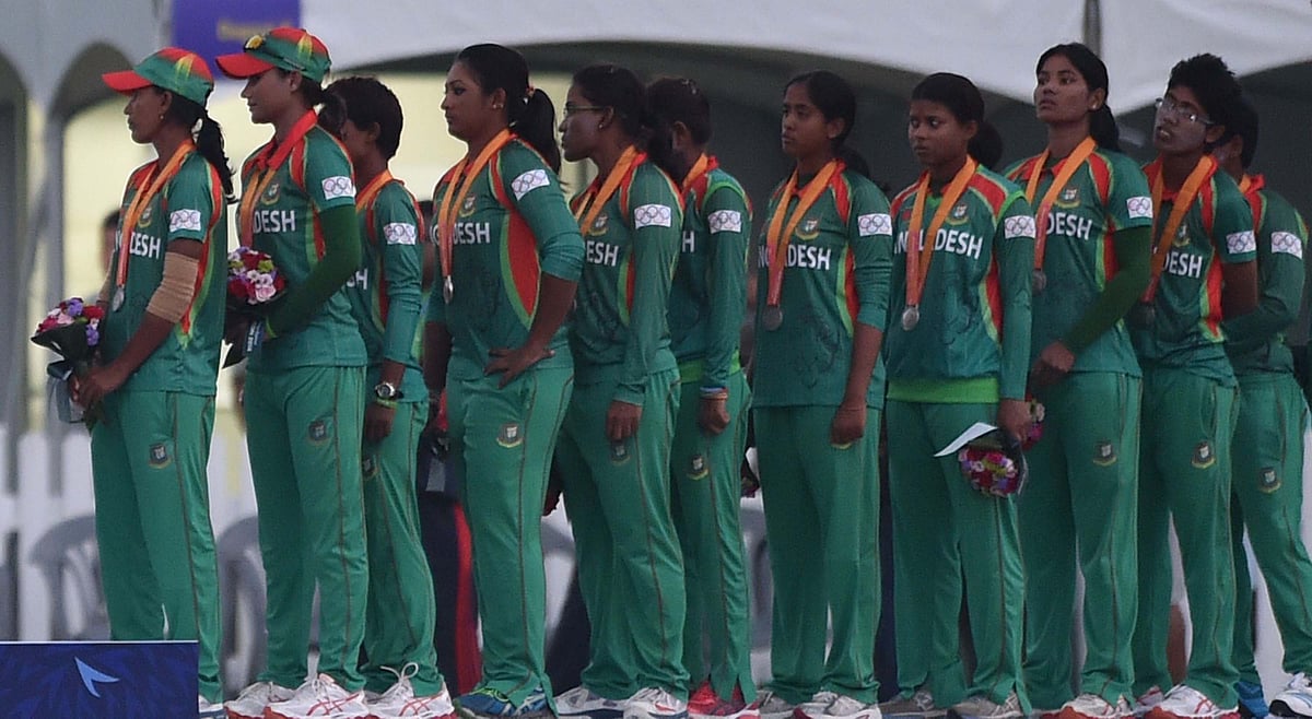 Silver medalists from Bangladesh stand for a flag rising ceremony after the medal ceremony following the women's cricket final at the Yeonhui Cricket Ground during the 17th Asian Games in Incheon on September 26, 2014. AFP