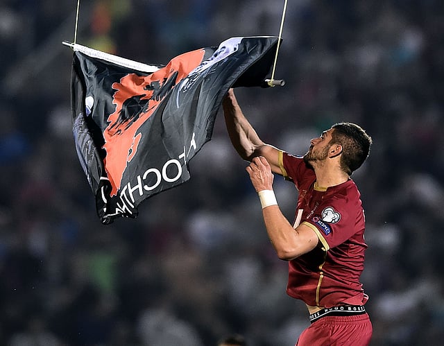 Serbia's Stefan Mitrovic grabs a flag with Albanian national symbols flown by a remotely operated drone during the Euro 2016 group I football match between Serbia and Albania in Belgrade on October 14, 2014. Photo: AFP