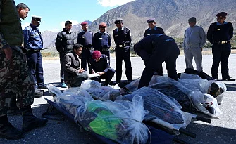 Nepalese police prepare to carry body of a trekker into a plane at Jomsom airport to be transported to Kathmandu on October 17, 2014. AFP