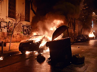 Cars burn in central Athens' Exarchia district, after being set on fire by young anarchists at the end of a demonstration. Several hundreds of people protested in Athens against a compromise loan deal between Greece and its international creditors. AFP