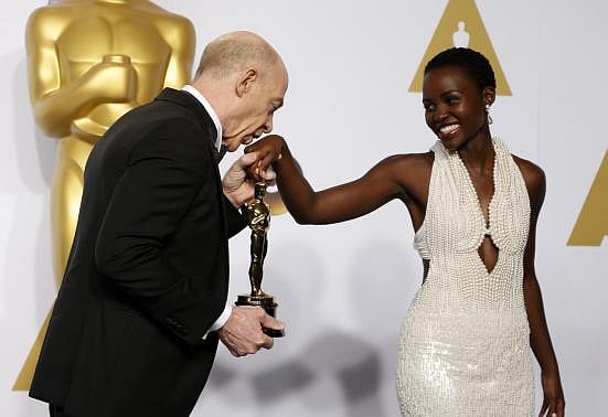 J.K. Simmons, winner of the award for best supporting actor nominee for his role in 'Whiplash,' kisses the hand of presenter Lupita Nyong'o during the 87th Academy Awards. Photo: Reuters