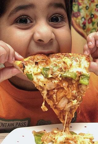 An obese boy takes junk food.