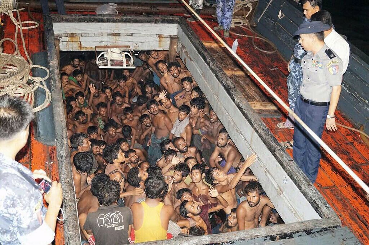 Migrants huddle in the compartment of a cargo vessel. AFP
