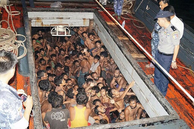 Migrants huddle in the compartment of a cargo vessel. AFP