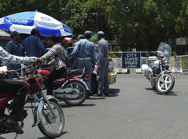 Pakistani traffic police gather at the end of a cordoned-off street leading to the hotel where the Zimbabwe and Pakistani cricket teams are staying in Lahore on May 30, 2015. AFP
