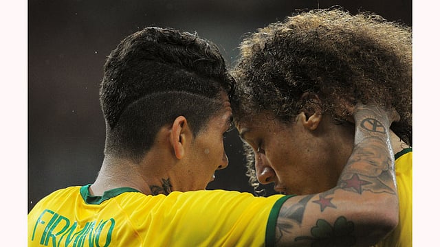 Brazil"s Firmino (L) celebrates with David Luiz after scoring against Honduras during their friendly soccer match in Porto Alegre, Brazil, June 10, 2015. Photo: Reuters