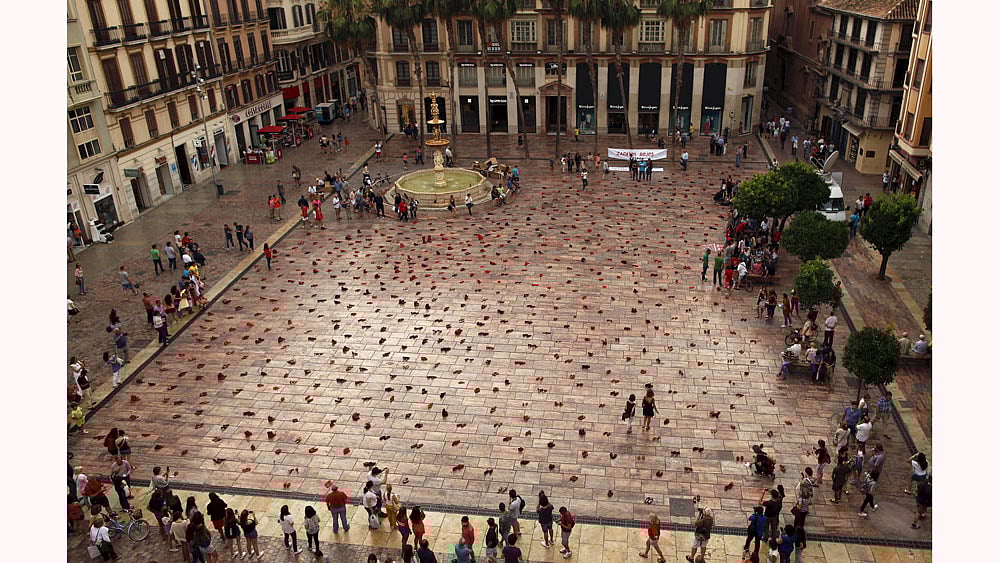 People look at an art installation of 745 pairs of female red shoes, put on display by Mexican visual artist Elina Chauvet to protest against gender violence and femicide, at La Constitucion Square in Malaga, southern Spain, June 12, 2015.Photo: Reuters
