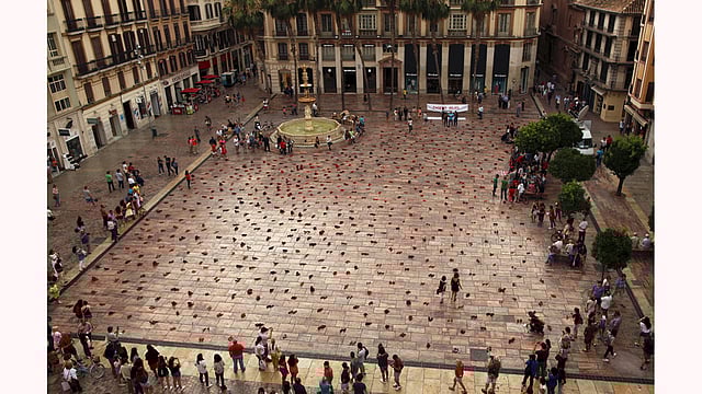 People look at an art installation of 745 pairs of female red shoes, put on display by Mexican visual artist Elina Chauvet to protest against gender violence and femicide, at La Constitucion Square in Malaga, southern Spain, June 12, 2015.Photo: Reuters
