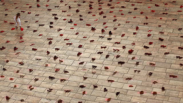 A woman tries to catch a balloon in an art installation of 745 pairs of female red shoes, put on display by Mexican visual artist Elina Chauvet to protest against gender violence and femicide. Photo: Reuters