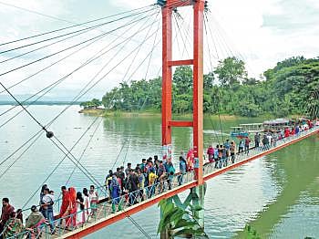 Photo shows people crossing the hanging bridge of Parjatan Holiday Complex in Rangamati town on Monday. Photo: Prothom Alo