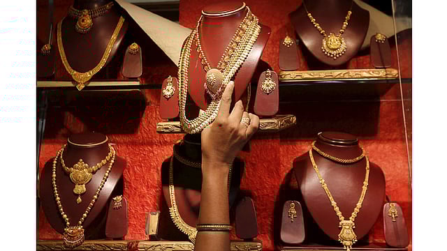 A saleswoman keeps a gold necklace in a shelve at a showroom in Mumbai, India, August 13, 2015. Photo: Reuters