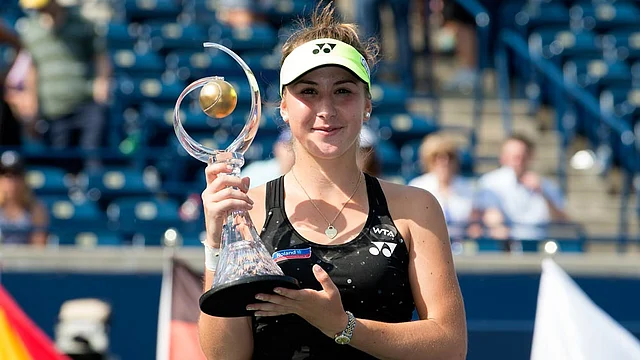 Belinda Bencic of Switzerland holds up the Rogers Cup trophy after winning the finals match after Halep retired from the match during the Rogers Cup tennis tournament on 15 August. Photo: Reuters