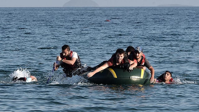 Syrian migrants paddle their dinghy to the shores of the Greek island of Kos on August 17, 2015 after their small engine broke down as they motored across the sea from Turkey. Photo: AFP