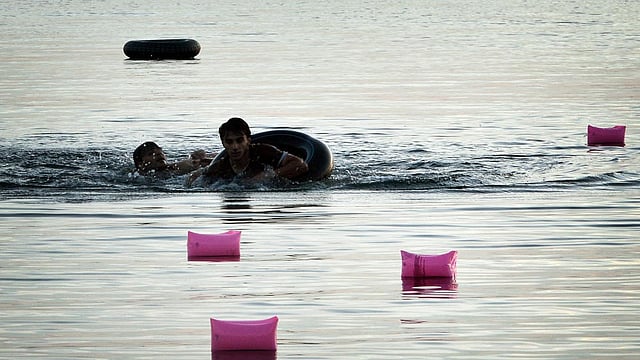 Syrian migrants swim towards the beach after arriving on an overcrowded dinghy to the Greek island of Kos, on August 15, 2015. Photo: AFP