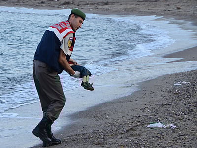 A Turkish police officer carries a migrant child's dead body off the shores in Bodrum, southern Turkey. Photo: AFP