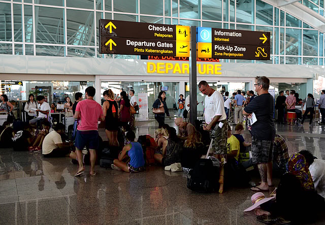Passengers wait for information on delayed and cancelled flights at the international departure area of Bali's Ngurah Rai Airport in Denpasar on November 4, 2015. AFP