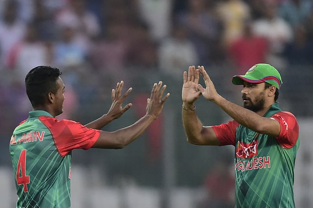 Bangladesh cricketer Al-Amin Hossain (L) celebrates with captain Mashrafe Bin Mortaza after the dismissal of Zimbabwe cricketer Regis Chakabva during the first T20 cricket match between Bangladesh and Zimbabwe at the Sher-e Bangla National Stadium in Dhaka on November 13, 2015. AFP