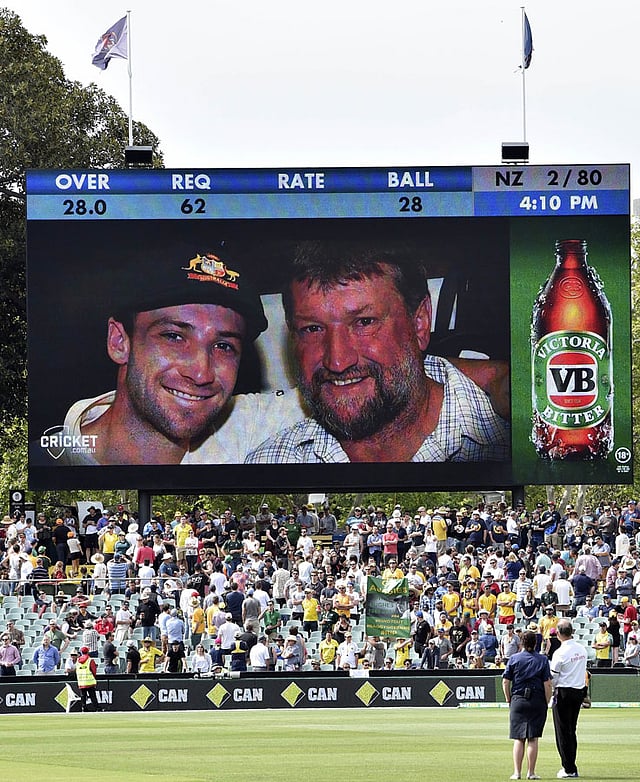 Spectators pay their respects to the late Phillip Hughes (L on screen) during the first day-night cricket Test match between Australia and New Zealand at the Adelaide Oval on November 27, 2015. AFP