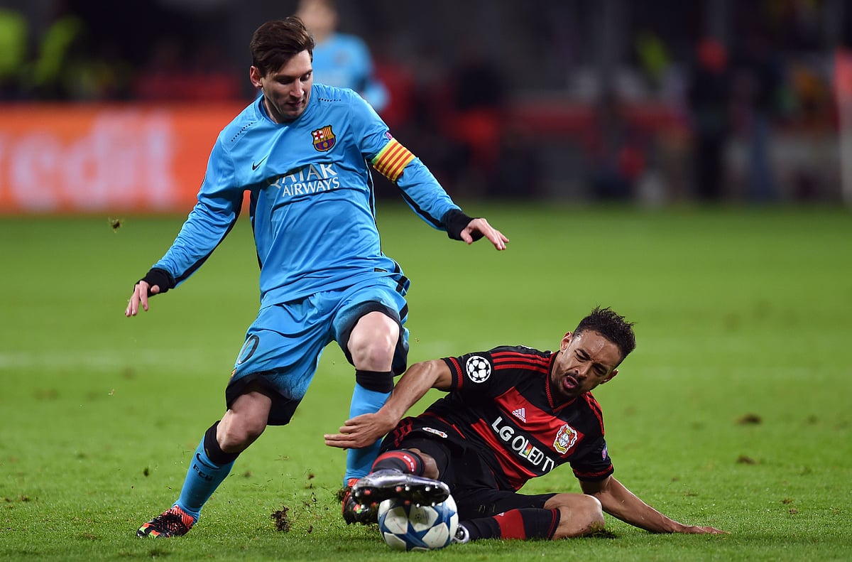Leverkusen’s midfielder Karim Bellarabi ® vies with Barcelona´s Argentinian striker Lionel Messi during the Group E, second-leg UEFA Champions League football match Bayer 04 Leverkusen vs FC Barcelona. Photo: AFP